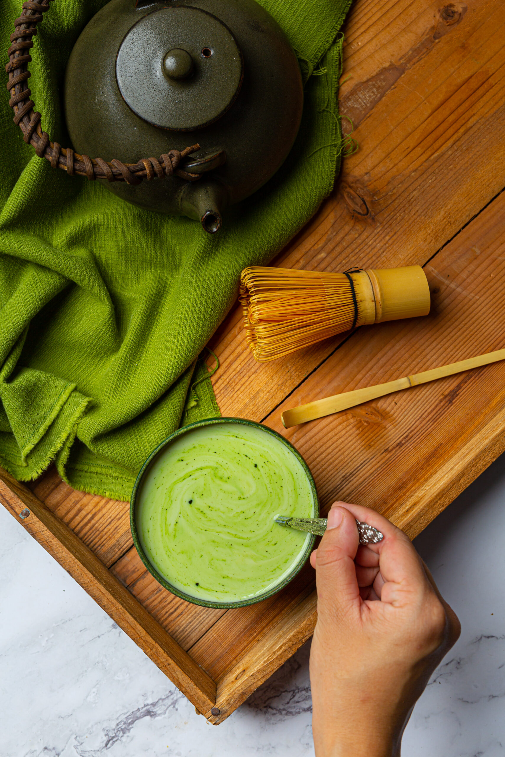 hot green tea in a glass with cream topped with green tea, decor